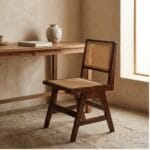 Chandigarh wooden dining chair beside a light-toned dining table