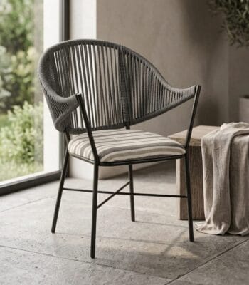 Curve outdoor chair with striped cushion in a garden-facing living space