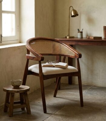 Derby cane dining chair at a wooden desk in a warm interior