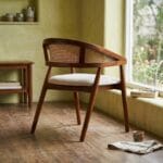 Derby wooden armchair beside a dining table by a garden window