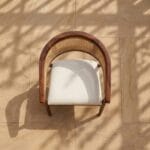 Derby wooden armchair front view against a plaster wall