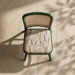 Goa cane dining chair front view against a warm plaster wall