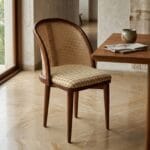 Kaen wooden dining chair beside a dining table in warm daylight