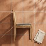 Moon dining chair side profile against a terracotta tiled wall