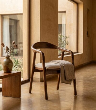 Neerja wooden armchair beside a console table in a warm hallway
