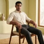 Guest seated on the Neerja wooden dining chair in a sunlit room