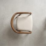 Neerja wooden armchair side profile against a plaster wall
