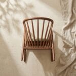 Pickle dining armchair front view against a plaster wall