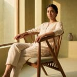 Guest seated on the Pickle wooden dining chair in a sunlit room