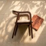 Rena wooden dining chair side profile in dappled light