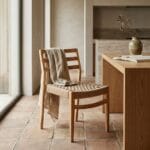 Sara wooden dining chair at a dining table with a throw over the back